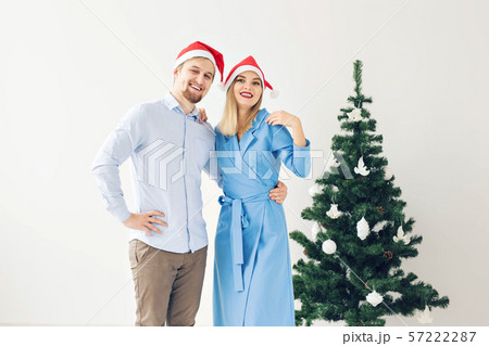 Winter holidays and family concept - Happy young couple near Christmas tree at home Winter holidays and family concept - Happy young couple near Christmas tree at home 57222287