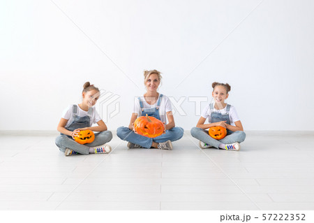 Happy halloween and holidays concept - A mother and her daughters with pumpkins. Happy family 57222352