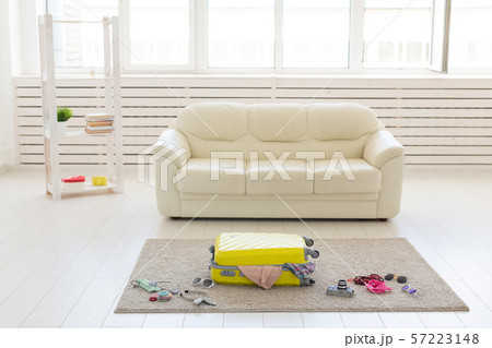 Trip, travel and holidays concept - collecting things for the trip in suitcase Trip, travel and holidays concept - collecting things for the trip in suitcase 57223148