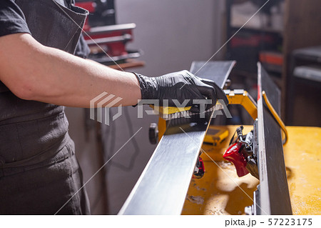 Work and repair concept - a man's hands repairing the ski by rubbing a paraffin 57223175