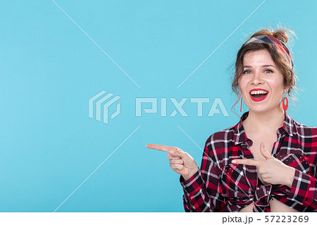Positive beautiful young woman in a plaid vintage shirt looking at the camera and smiling posing on Positive beautiful young woman in a plaid vintage shirt looking at the camera and smiling posing on 57223269