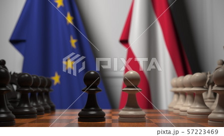 Flags of the EU and Austria behind chess board. The first pawn moves in the beginning of the game 57223469