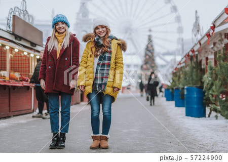Friendly girls standing in the middle of festive market 57224900