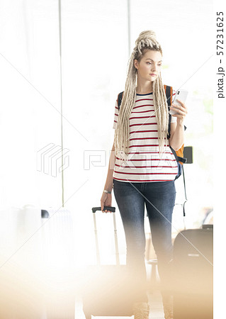 訪日外国人旅行者 ロシア人 スマホを見ながらキャリーケースを引く女性の写真素材