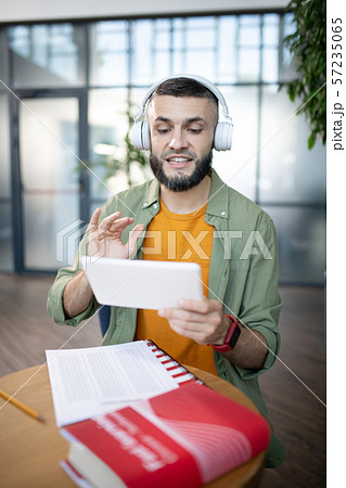 Bearded student studying foreign language repeating after recording 57235065