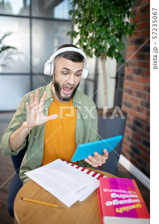 Student wearing earphones using tablet while studying Student wearing earphones using tablet while studying 57235067