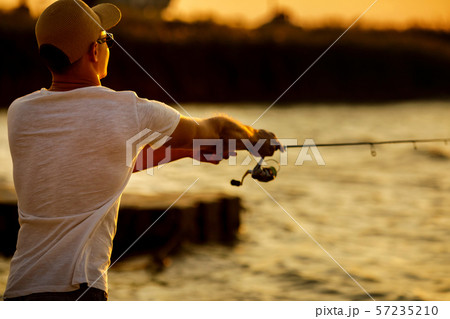 Young man fishing at sea Young man fishing at sea 57235210