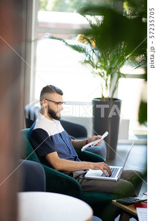 Businessman working on laptop sitting in nice office 57235705