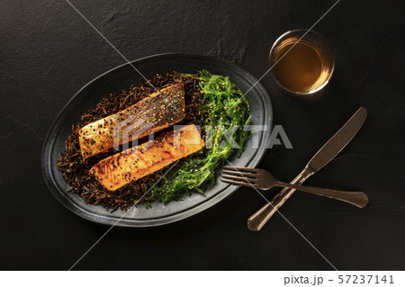 Salmon with sesame seeds, wakame seaweed and wild rice, shot from the top with a glass of white wine 57237141