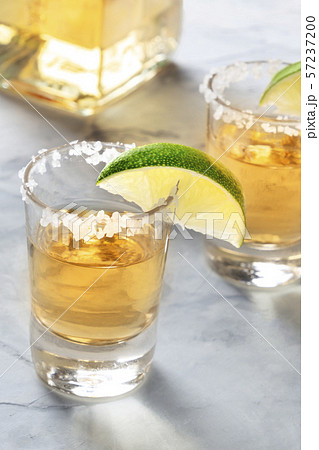 Golden tequila shots with lime slices, salt rim, and a bottle Golden tequila shots with lime slices, salt rim, and a bottle 57237200
