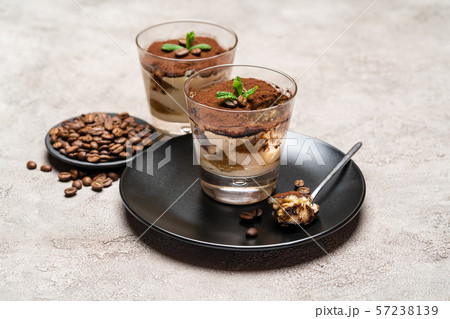 Portion of Classic tiramisu dessert in a glass cup on concrete background 57238139