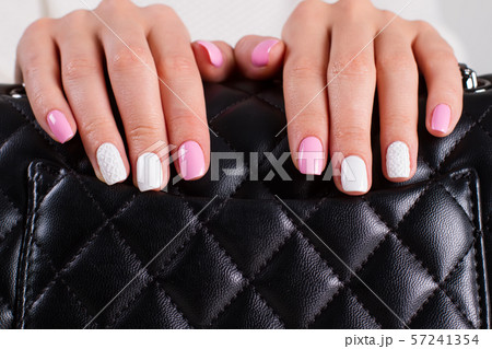Women's fingers on the black bag. 57241354
