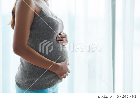 Woman touching her baby bump Woman touching her baby bump 57245761