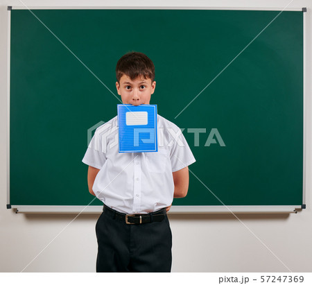 Portrait of a school boy posing with blue exercise Portrait of a school boy posing with blue exercise 57247369