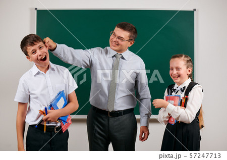 Portrait of a teacher grabs schoolboy's ear, who Portrait of a teacher grabs schoolboy's ear, who 57247713