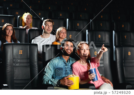 cheerful ginger girl showing her favourite actor while watching movie 57249320