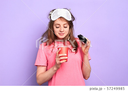 Student girl looks inside of paper cup, wonders how much coffee is left 57249985