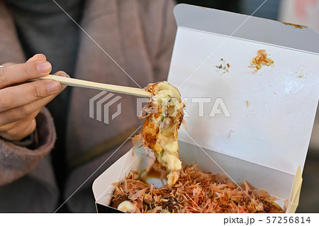 Takoyaki street food on woman hands. Takoyaki street food on woman hands. 57256814