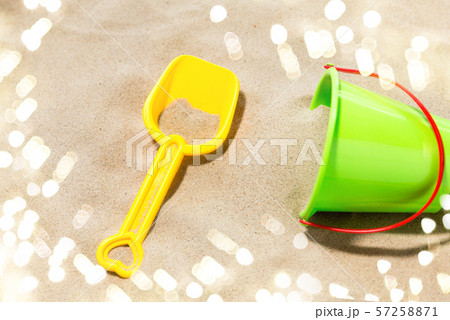 close up of toy bucket and shovel on beach sand close up of toy bucket and shovel on beach sand 57258871