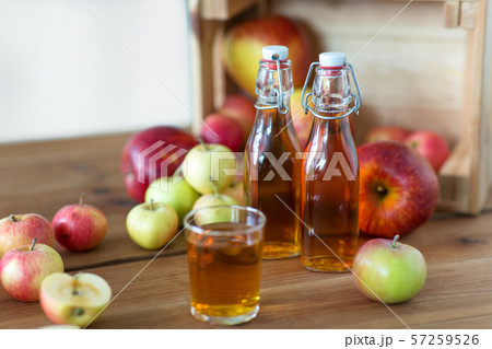glass and bottles of apple juice on wooden table glass and bottles of apple juice on wooden table 57259526