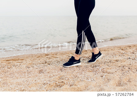 Close-up image of feet in sneakers walking along Close-up image of feet in sneakers walking along 57262784
