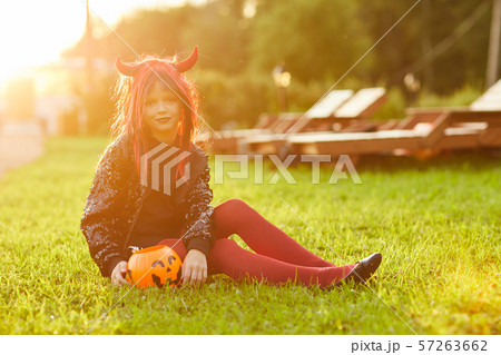 Halloween Girl Sitting on Grass 57263662