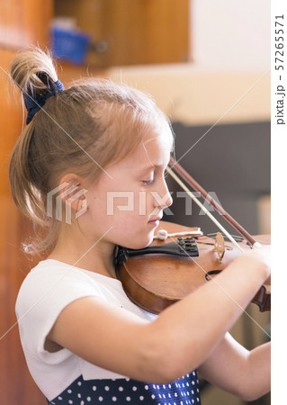Child, little girl playing violin indoors in music class. vertical photo 57265571