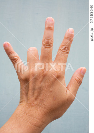 Trigger Finger lock on ring finger of woman's back left hand, Suffering from pain, On Blue-grey colour background, Close up & Macro shot, Office syndrome, Health care concept Trigger Finger lock on ring finger of woman's back left hand, Suffering from pain, On Blue-grey colour background, Close up & Macro shot, Office syndrome, Health care concept 57265646