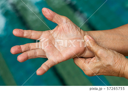 Trigger Finger, Senior woman's left hand massaging her right hand Suffering from pain, Close up and macro shot, Swimming pool background, Health care and massage asian body concept Trigger Finger, Senior woman's left hand massaging her right hand Suffering from pain, Close up and macro shot, Swimming pool background, Health care and massage asian body concept 57265755