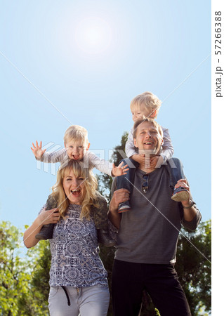 Happy kids sitting on pearents shoulder. Happy kids sitting on pearents shoulder. 57266388