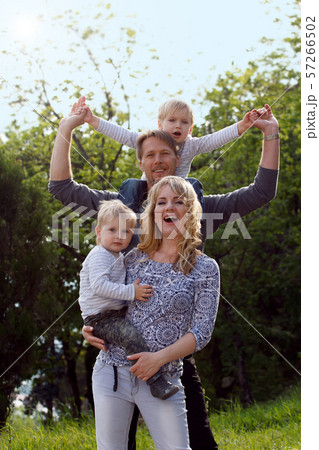 Happy kids sitting on pearents shoulder. 57266502