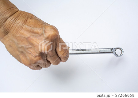 Senior Woman's right hand holding wrench on white background, Construction building and repair tool concept 57266659