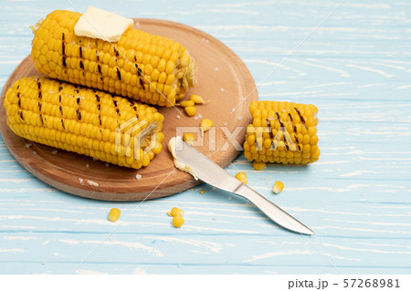 Grilled hot Corn cob lies on cutting board blue Grilled hot Corn cob lies on cutting board blue 57268981