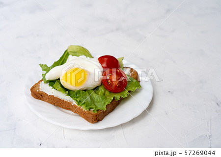 Sandwich with fried eggs salad and tomato on a 57269044