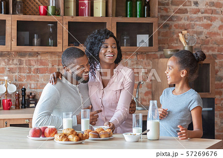 Cheerful african family having healthy breakfast together Cheerful african family having healthy breakfast together 57269676