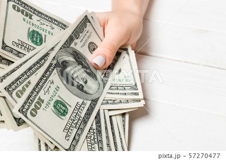 Female hand holding a bundle of one hundred dollar 57270477
