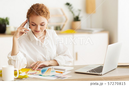 Dressmaker speaking on cellphone and looking at palette Dressmaker speaking on cellphone and looking at palette 57270815