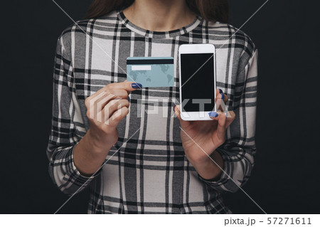 Closeup view of cellphone and credit plastic card in woman's hands. 57271611
