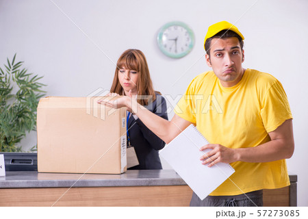 Young male courier delivering box to hotel's reception 57273085