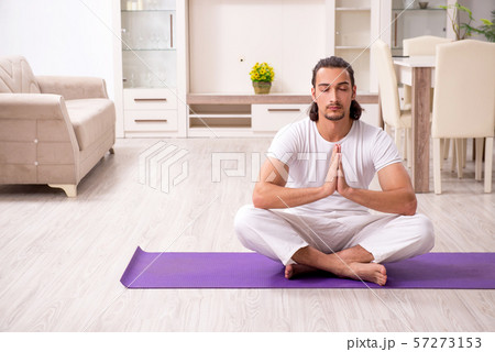 Young man doing physical exercises at home 57273153