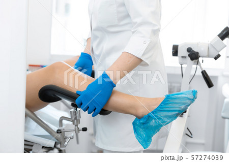 The gynecologist helps the patient to sit in the The gynecologist helps the patient to sit in the 57274039