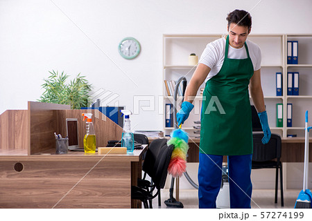 Young handsome contractor cleaning the office Young handsome contractor cleaning the office 57274199