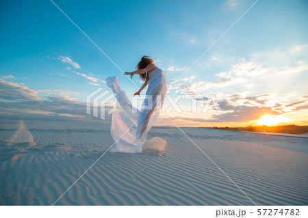 A girl in a fly white dress dances and poses in A girl in a fly white dress dances and poses in 57274782