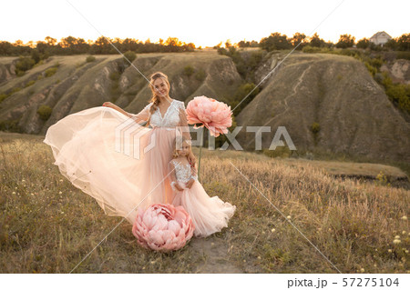 Mom with daughter in pink fairy-tale dresses walk 57275104