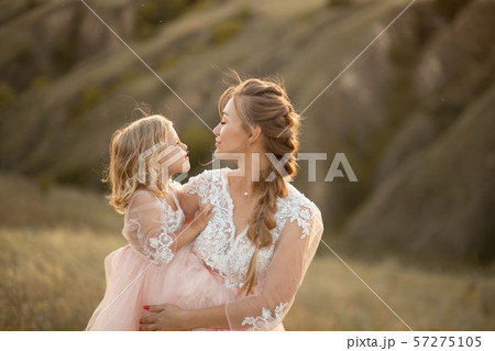 Mom with daughter in pink fairy-tale dresses walk Mom with daughter in pink fairy-tale dresses walk 57275105