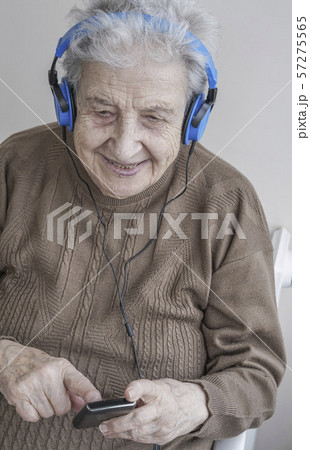 Senior woman listening music with headphones and Senior woman listening music with headphones and 57275565
