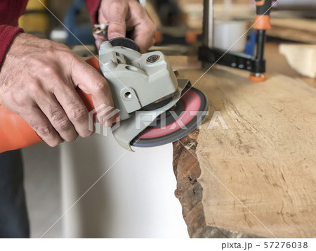 closeup hands of a carpenter working with emery 57276038