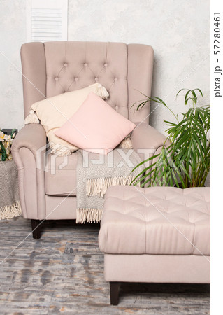 Stylish beige armchair with pink pillows in a bright minimalist interior 57280461