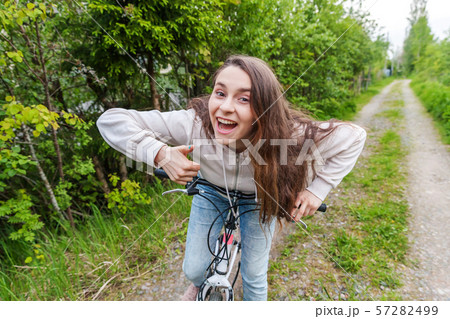 Young woman riding bicycle in summer city park outdoors. Active people. Hipster girl relax and rider 57282499