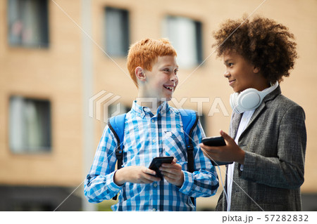 Two friends using phones Two friends using phones 57282832